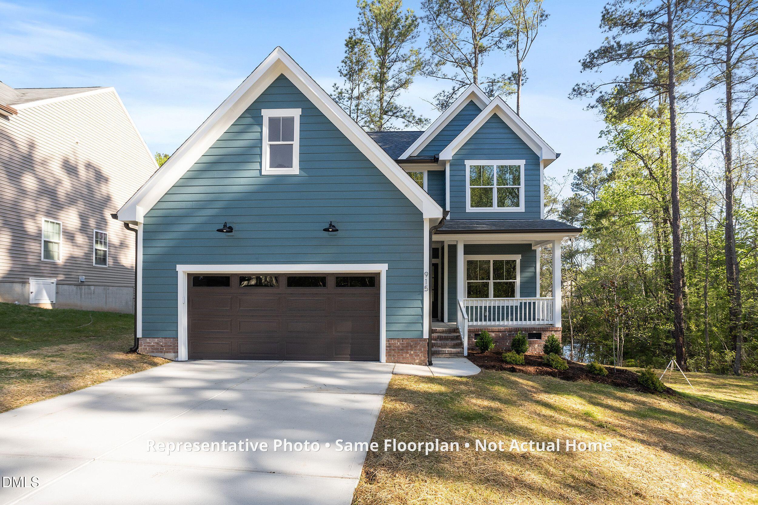 931 Woodland Road Creedmoor, NC 27522 - Photo 2 of 45 a view of a house with a yard and garage