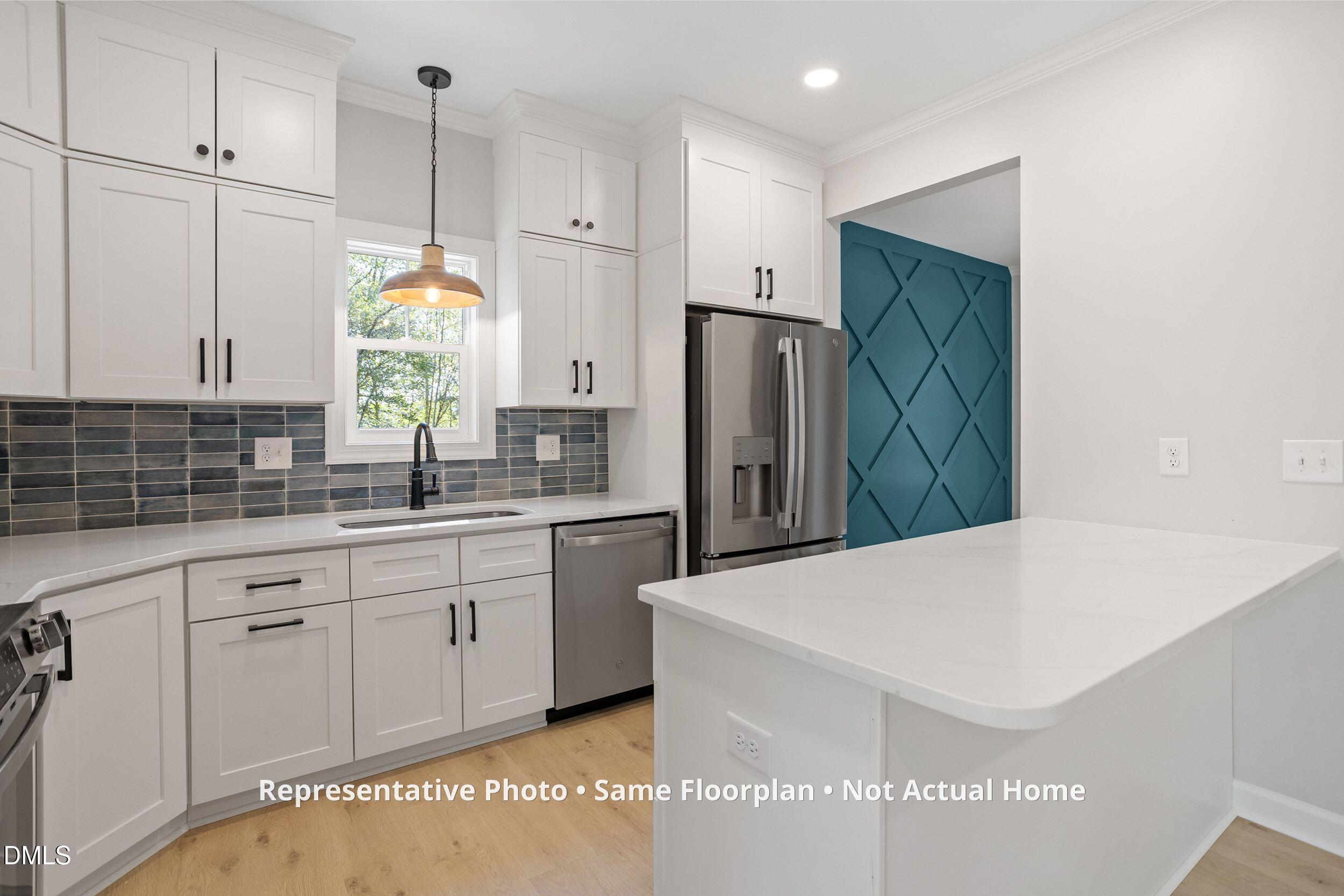 931 Woodland Road Creedmoor, NC 27522 - Photo 4 of 45 a kitchen with stainless steel appliances a refrigerator a sink a stove and white cabinets