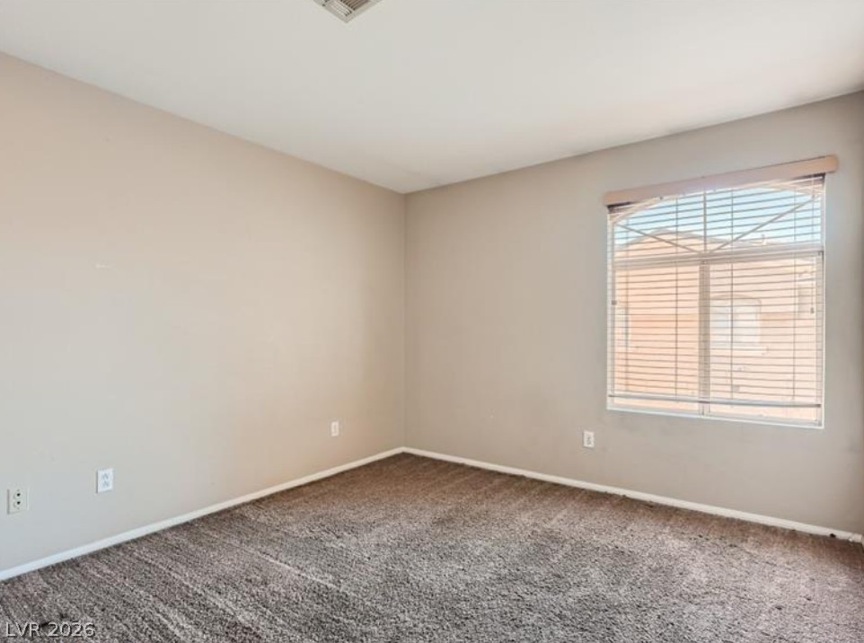 3950 South Sandhill Road, Unit 121 Las Vegas, NV 89121 - Photo 7 of 11 An airy bedroom with fresh carpet and natural light from the large window.