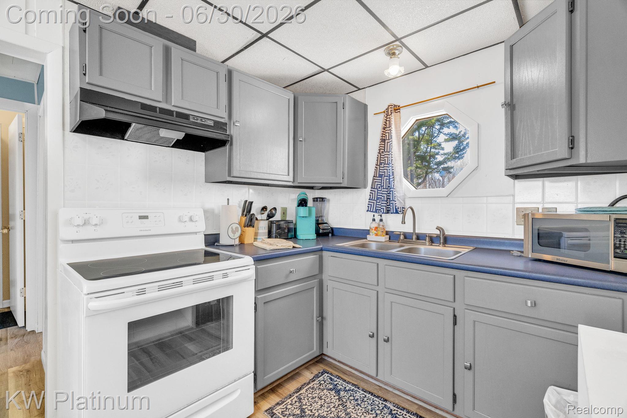 2235 South Lake Shore Road Harbor Beach, MI 48441 - Photo 62 of 99 Kitchen featuring gray cabinetry, blue countertops, a white electric range with overhead vent, and a dual basin stainless steel sink