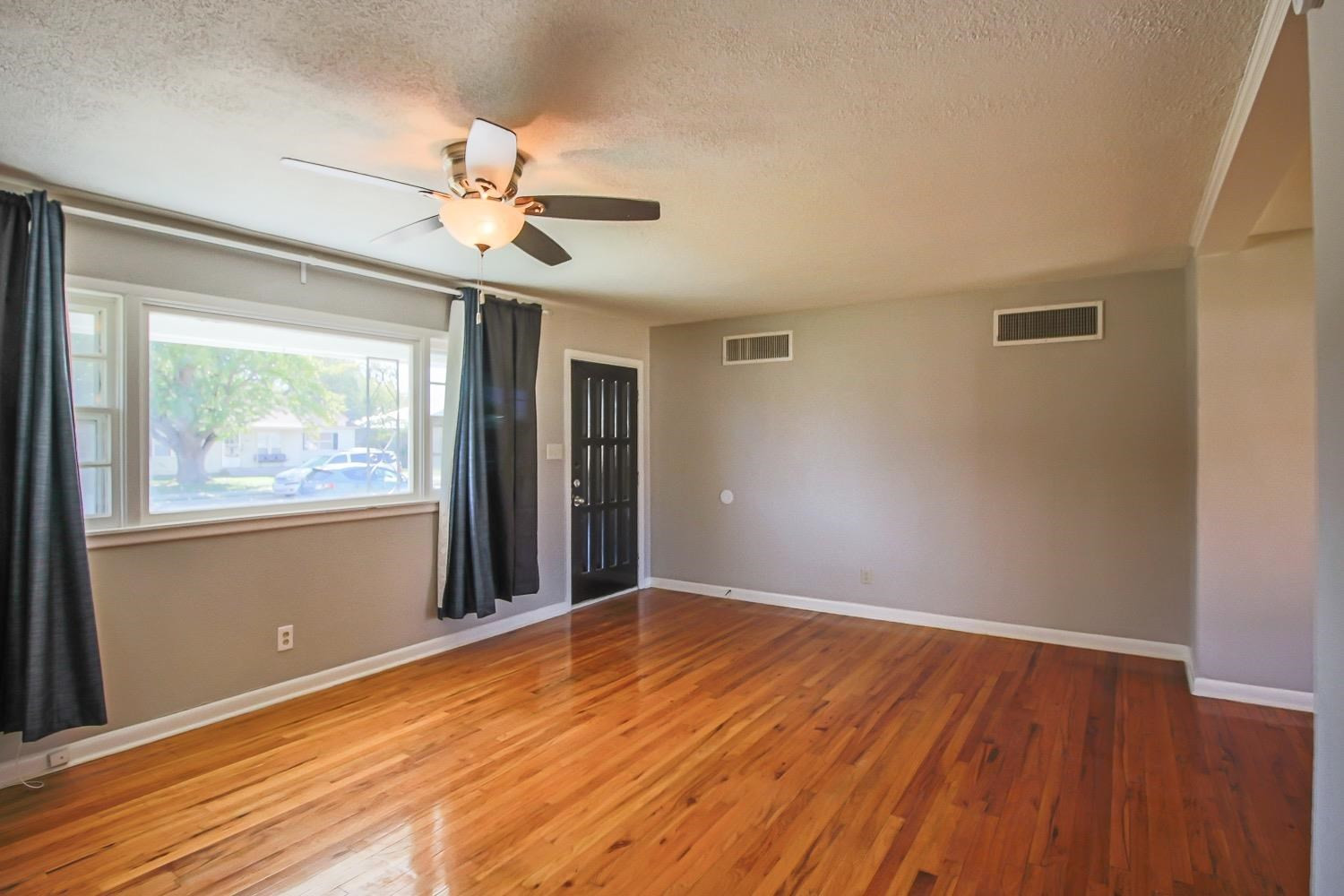 3814 32nd Street Lubbock, TX 79410 - Photo 4 of 10 a view of an empty room with window and wooden floor