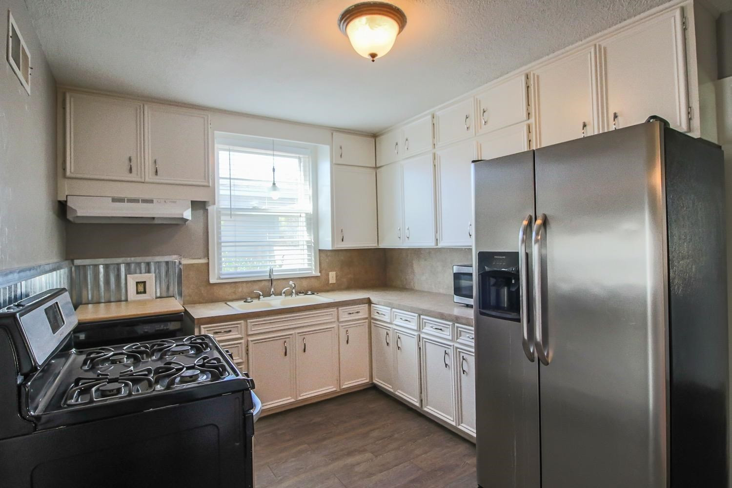 3814 32nd Street Lubbock, TX 79410 - Photo 7 of 10 a kitchen with stainless steel appliances granite countertop a sink stove and refrigerator