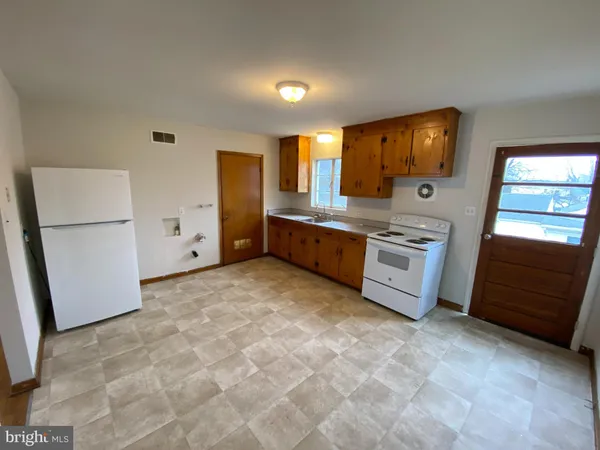 a large white kitchen with a stove a refrigerator a sink and dishwasher