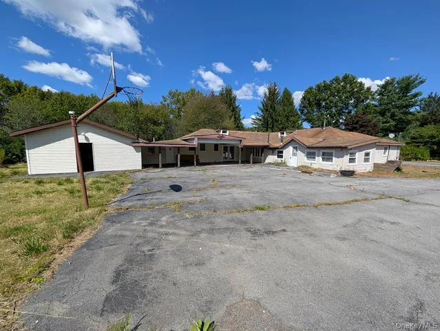 a view of a house with backyard and a tree