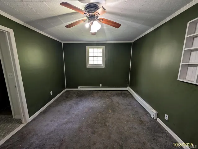 en empty room with windows and fan