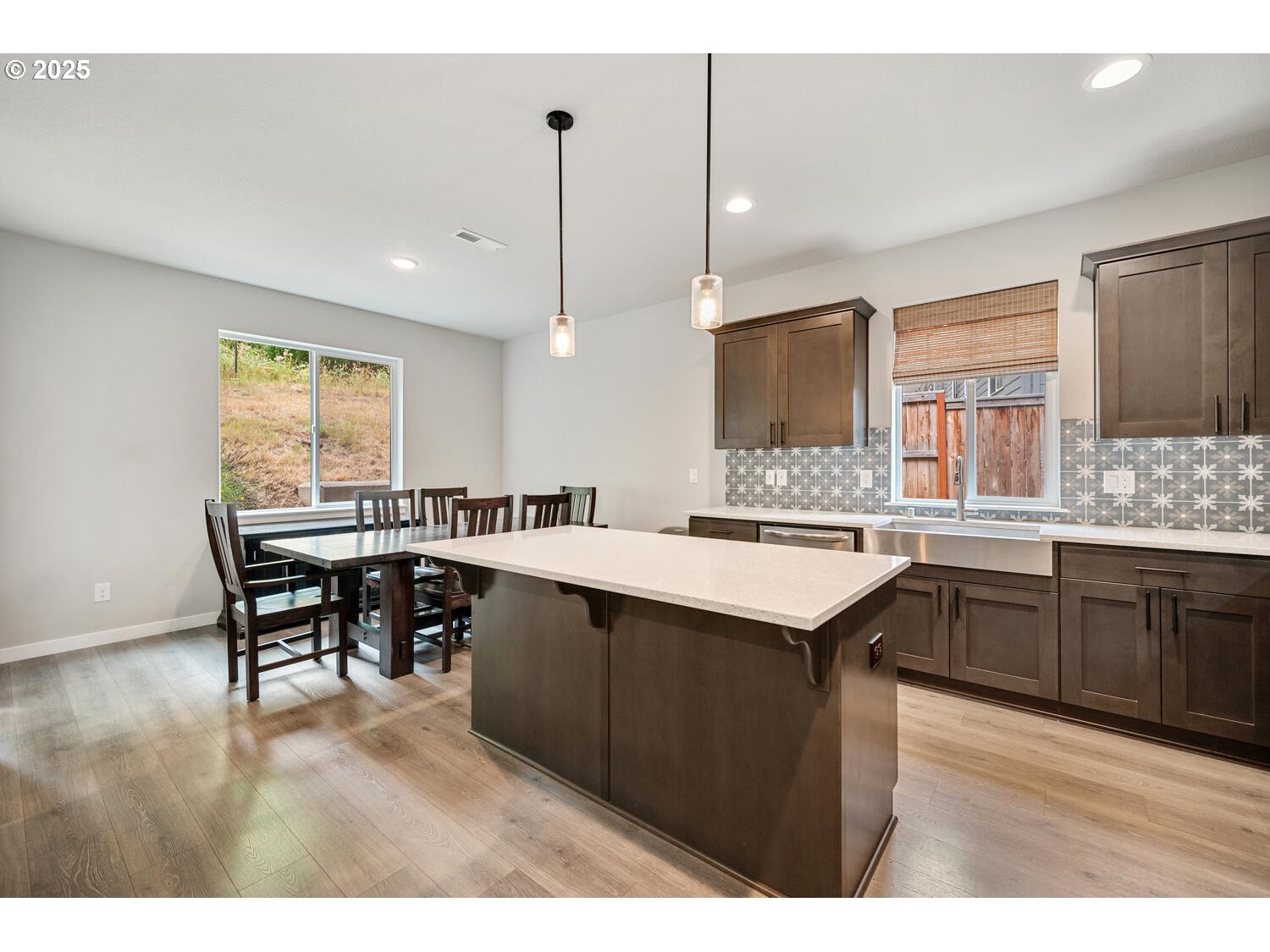 1809 Northeast 169th Street Ridgefield, WA 98642 - Photo 16 of 47 a kitchen with a stove a sink a kitchen island with chairs and wooden cabinets