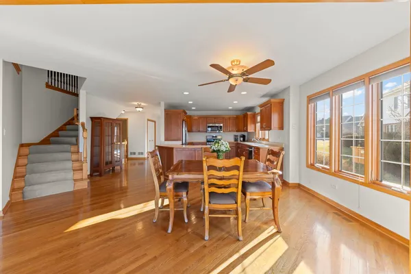 a kitchen with stainless steel appliances granite countertop a refrigerator a sink dishwasher a stove and a sink with wooden cabinets