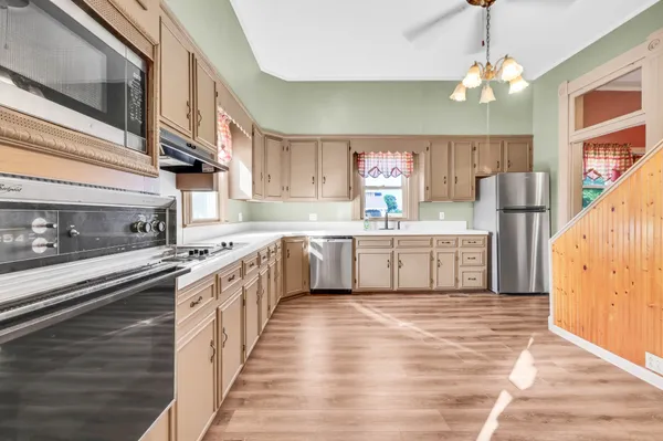 a bathroom with a sink a toilet a mirror and a window