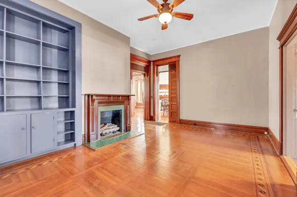a view of an empty room with window and wooden floor