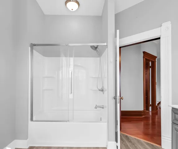 a view of an empty room with window and wooden floor