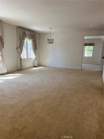 an empty room with a ceiling fan and window