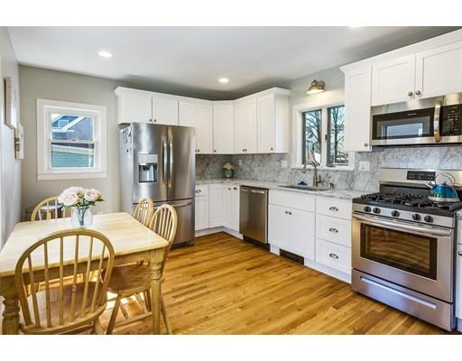 22 Berkeley Street Somerville, MA 02143 - Photo 9 of 28 a kitchen with stainless steel appliances kitchen island granite countertop a stove top oven a sink dishwasher and white cabinets with wooden floor