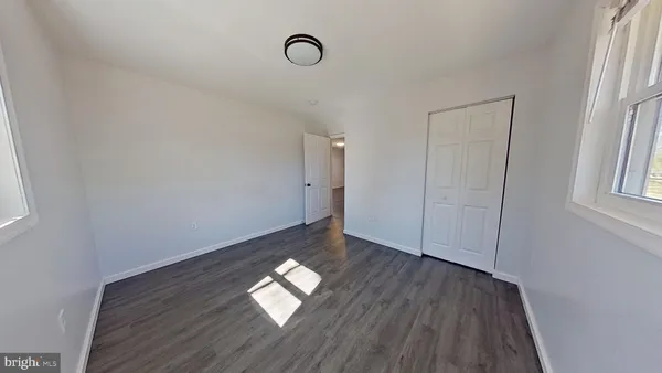 a view of empty room with wooden floor and window
