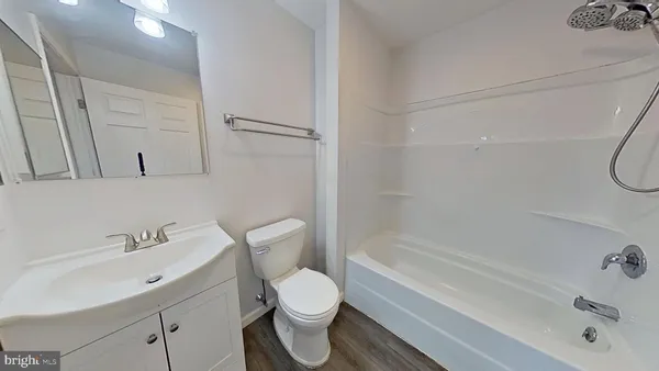 a bathroom with a bathtub shower sink vanity and toilet
