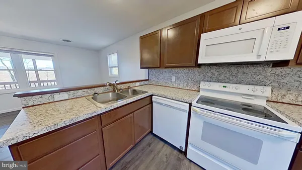 a kitchen with granite countertop cabinets sink and stainless steel appliances