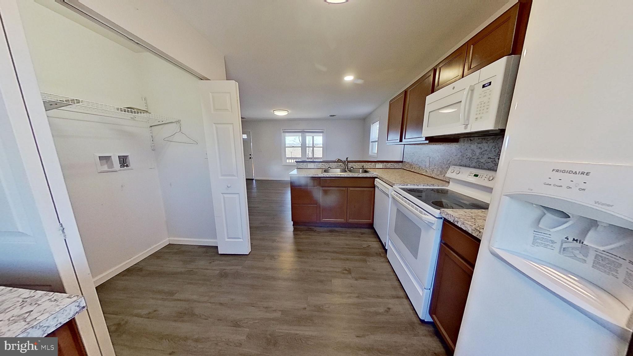 1821 Detters Mill Road Dover, PA 17315 - Photo 8 of 9 a kitchen with stainless steel appliances granite countertop a refrigerator a sink dishwasher a stove and white countertops with wooden floor