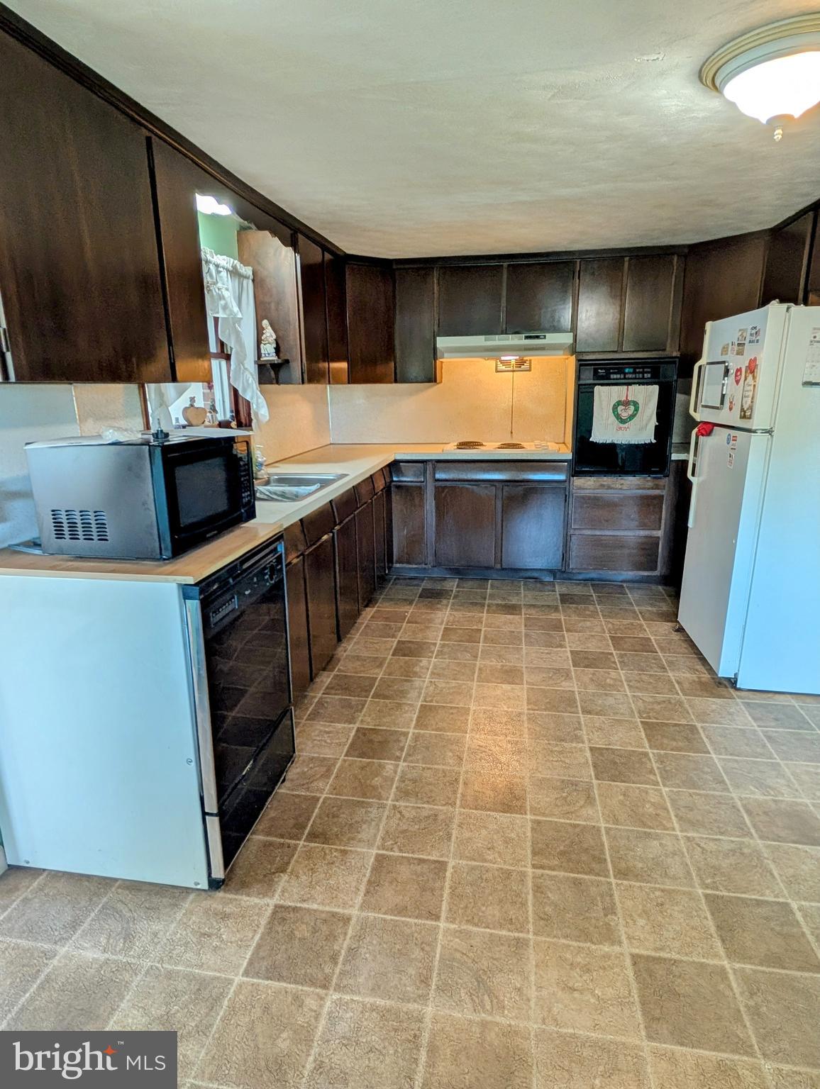 12706 High Point Road Felton, PA 17322 - Photo 7 of 56 a kitchen with stainless steel appliances a sink a stove top oven a counter space and cabinets