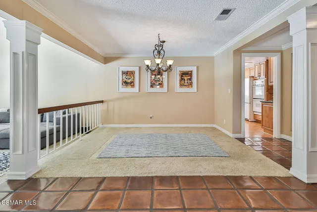 a view of a hallway with wooden floor and a chandelier