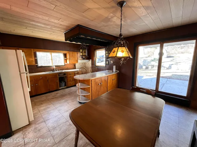 a living room with stainless steel appliances granite countertop furniture a fireplace a flat screen tv and a large window