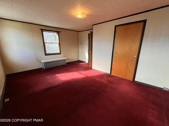 an empty room with windows and closet