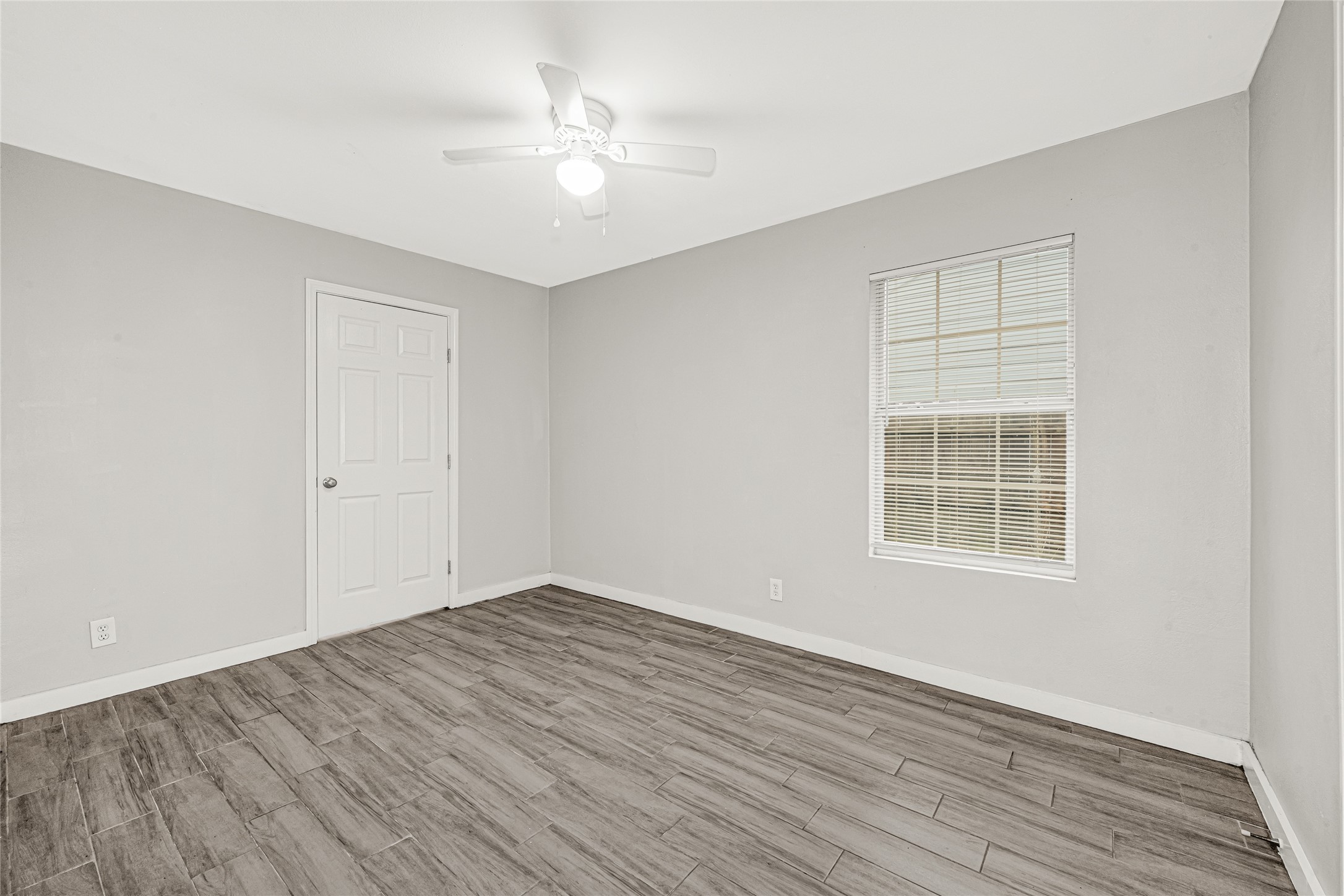5009 Bataan Road Houston, TX 77033 - Photo 19 of 24 wooden floor in an empty room with a window