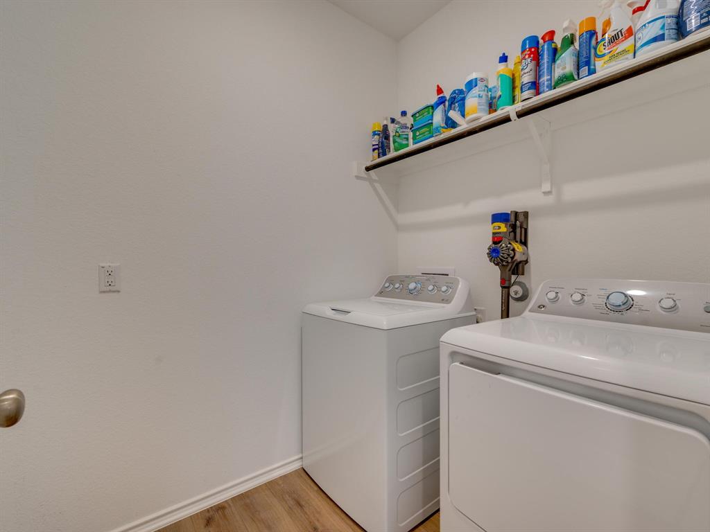 1208 Sweetspire Street Leander, TX 78641 - Photo 14 of 36 Dedicated laundry area featuring a built-in wall shelf for storage, wood-finish flooring, and white baseboards
