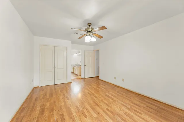 an empty room with a window and a fan