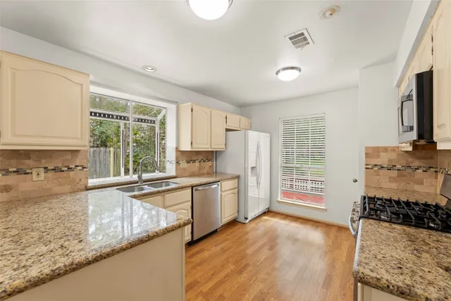 a kitchen with a sink a stove and cabinets