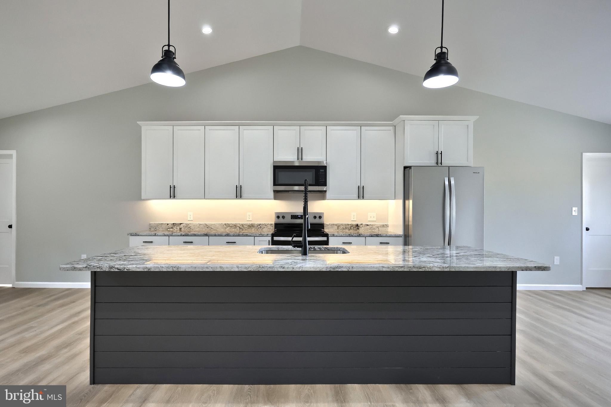 10620 Enfield Road Felton, PA 17322 - Photo 22 of 62 a kitchen with kitchen island granite countertop a sink cabinets and stainless steel appliances