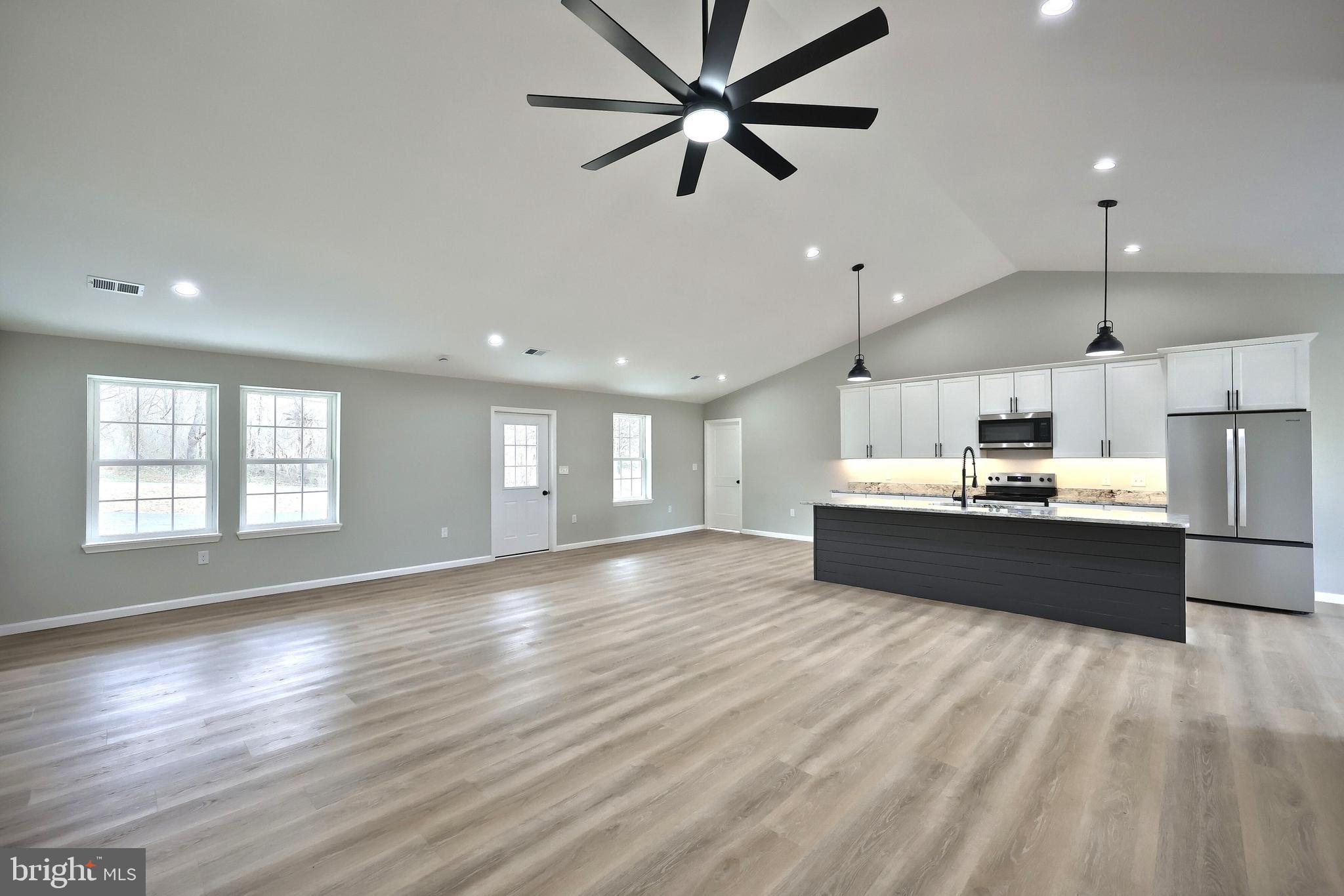 10620 Enfield Road Felton, PA 17322 - Photo 29 of 62 a large kitchen with stainless steel appliances kitchen island a large counter top a sink and a window