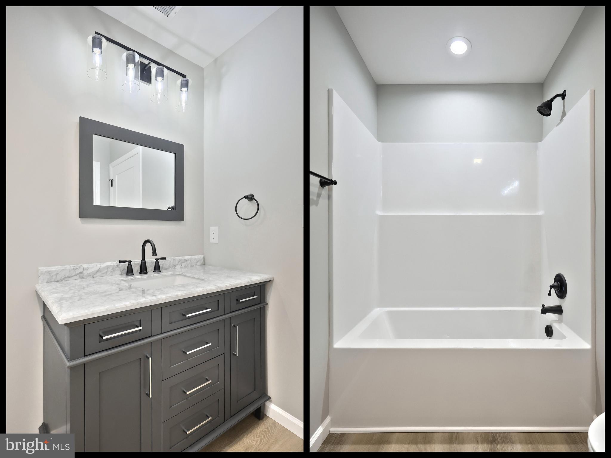 10620 Enfield Road Felton, PA 17322 - Photo 41 of 62 a bathroom with a granite countertop sink a mirror a bathtub and shower