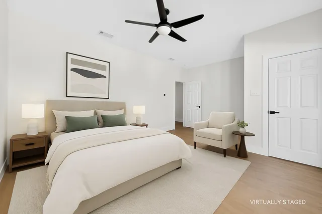 a spacious bedroom with a bed and a chandelier