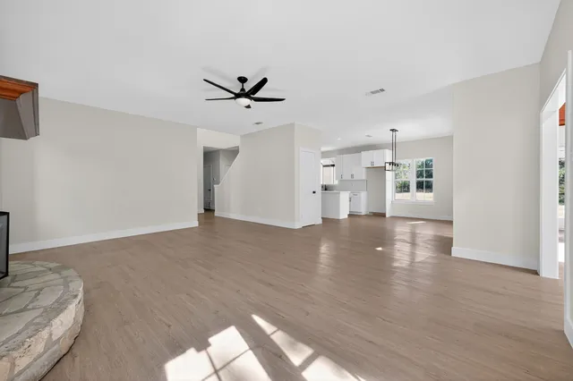 a view of empty room with wooden floor and window