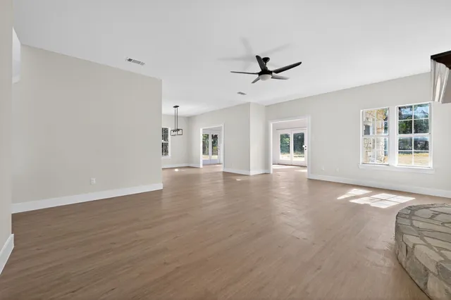 a view of a livingroom with wooden floor and a ceiling fan