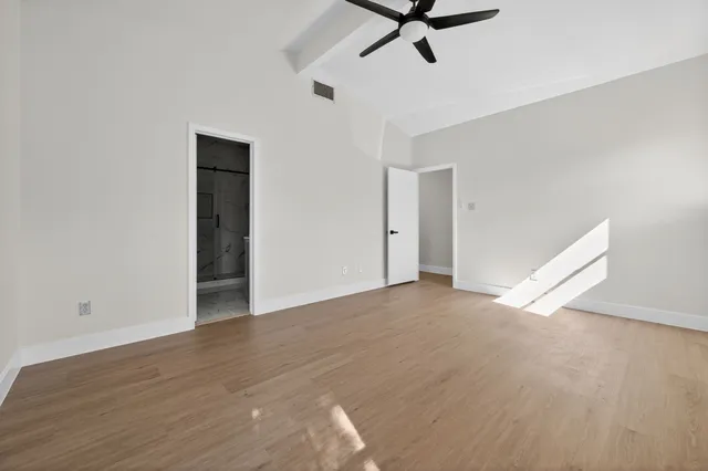 a view of a room with wooden floor and white walls