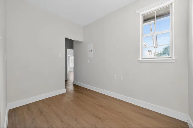 an empty room with wooden floor and closet