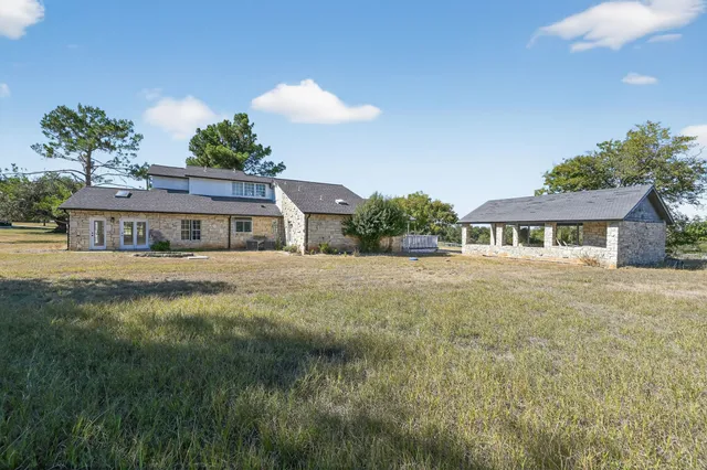 a front view of house with yard and trees around