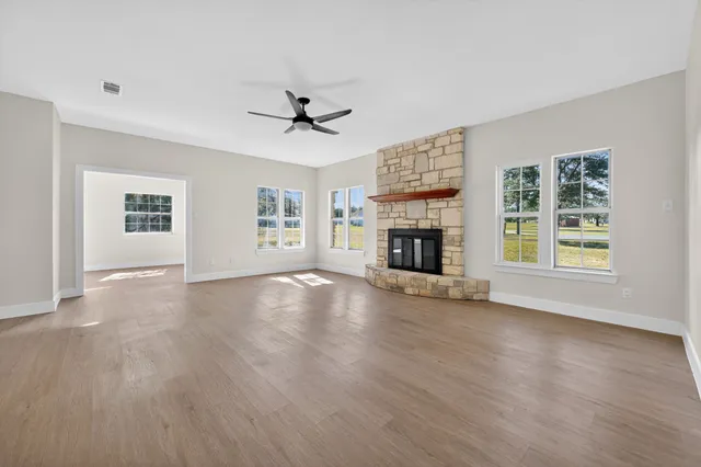 a view of an empty room with a fireplace and a window