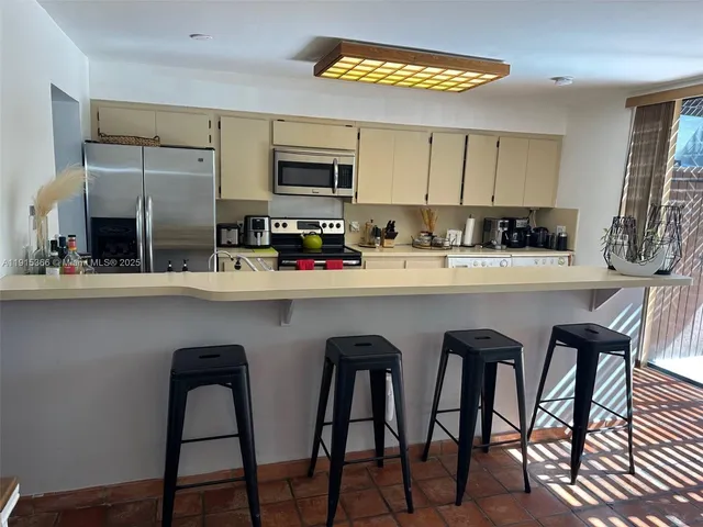 a kitchen with stainless steel appliances a sink table and chairs