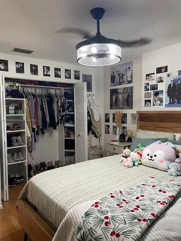 a bedroom with a large bed and a chandelier