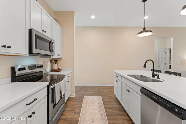 a kitchen with stainless steel appliances granite countertop a sink a stove and a refrigerator