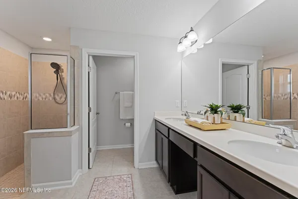 a bathroom with a double vanity sink a toilet and a mirror