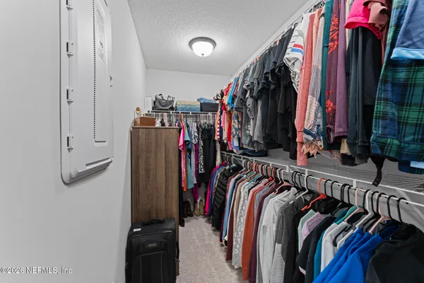 a view of walk in closet with clothes