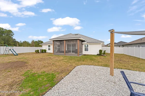 a view of a house with backyard and trees
