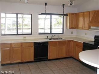 611 Southwest 57th Street Cape Coral, FL 33914 - Photo 3 of 9 a kitchen with granite countertop a sink window and cabinets