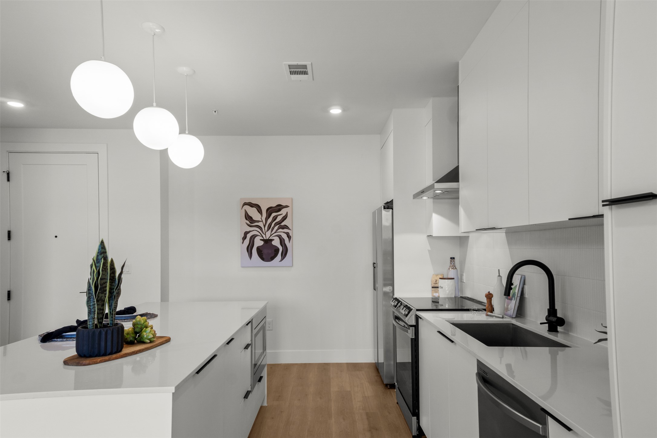 1701 Simond Avenue, Unit 418 Austin, TX 78723 - Photo 8 of 37 Kitchen with modern cabinets, white cabinets, appliances with stainless steel finishes.