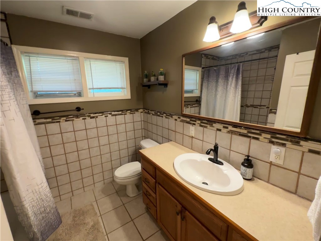 320 North Main Street Jefferson, NC 28640 - Photo 19 of 28 a bathroom with a sink a toilet and mirror