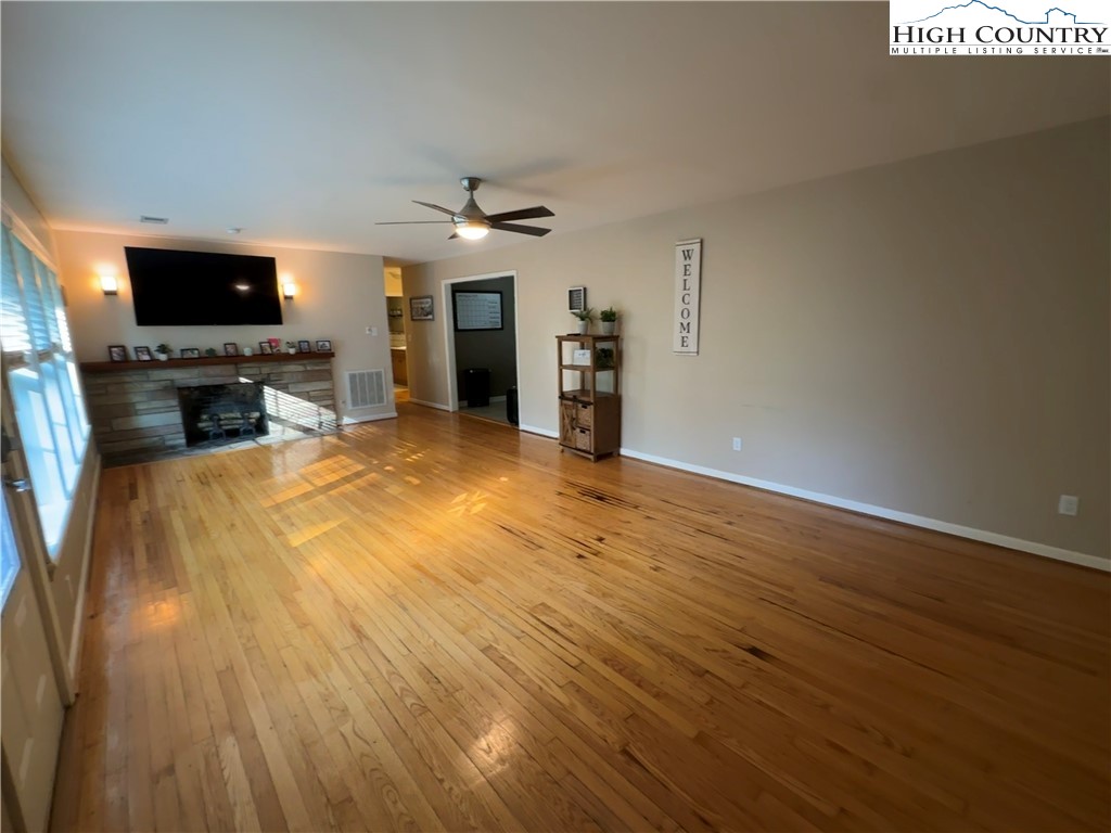 320 North Main Street Jefferson, NC 28640 - Photo 5 of 28 a view of a livingroom with a flat screen tv wooden floor and a ceiling fan