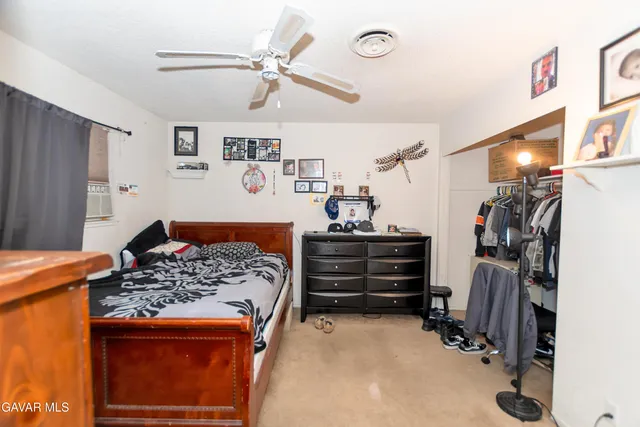 a bedroom with a bed and a ceiling fan