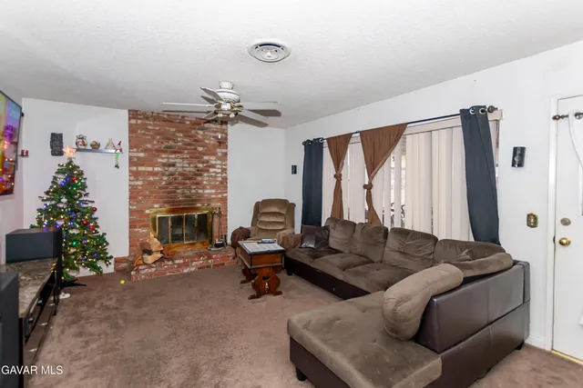 a living room with furniture a fireplace and a potted plant